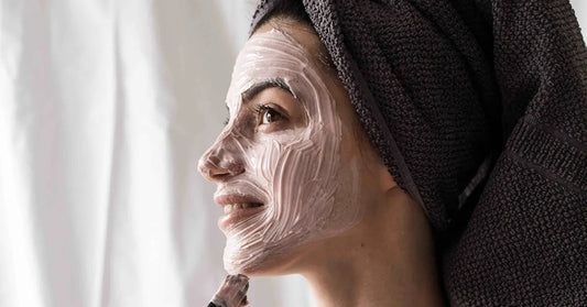 Femme appliquant un masque visage naturel parmi les 28 recettes chez elle