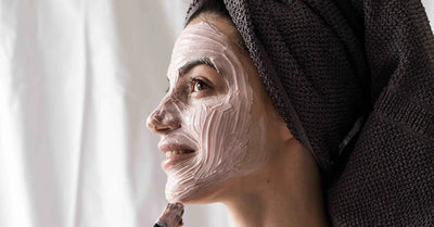 Femme appliquant un masque visage naturel parmi les 28 recettes chez elle