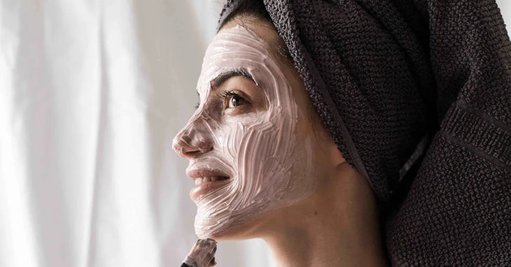 Femme appliquant un masque visage naturel parmi les 28 recettes chez elle