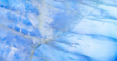 Texture naturelle de pierre de lune bleue avec adularescence, représentant les vertus apaisantes et spirituelles de cette gemme en lithothérapie.