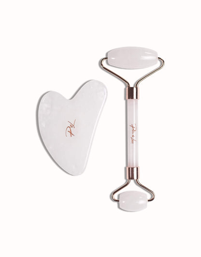 Gua sha et roller en cristal de roche naturel, présentés sur un fond blanc, mettant en valeur leur qualité et leur finition élégante.