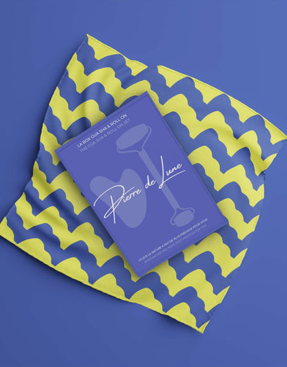 Packaging du coffret gua sha et roller "Pierre de Lune", présenté sur un tissu coloré, mettant en avant un design élégant et naturel.